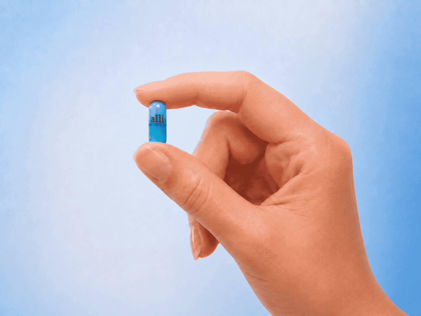 Alli (orlistat 60mg) capsule held between two fingers