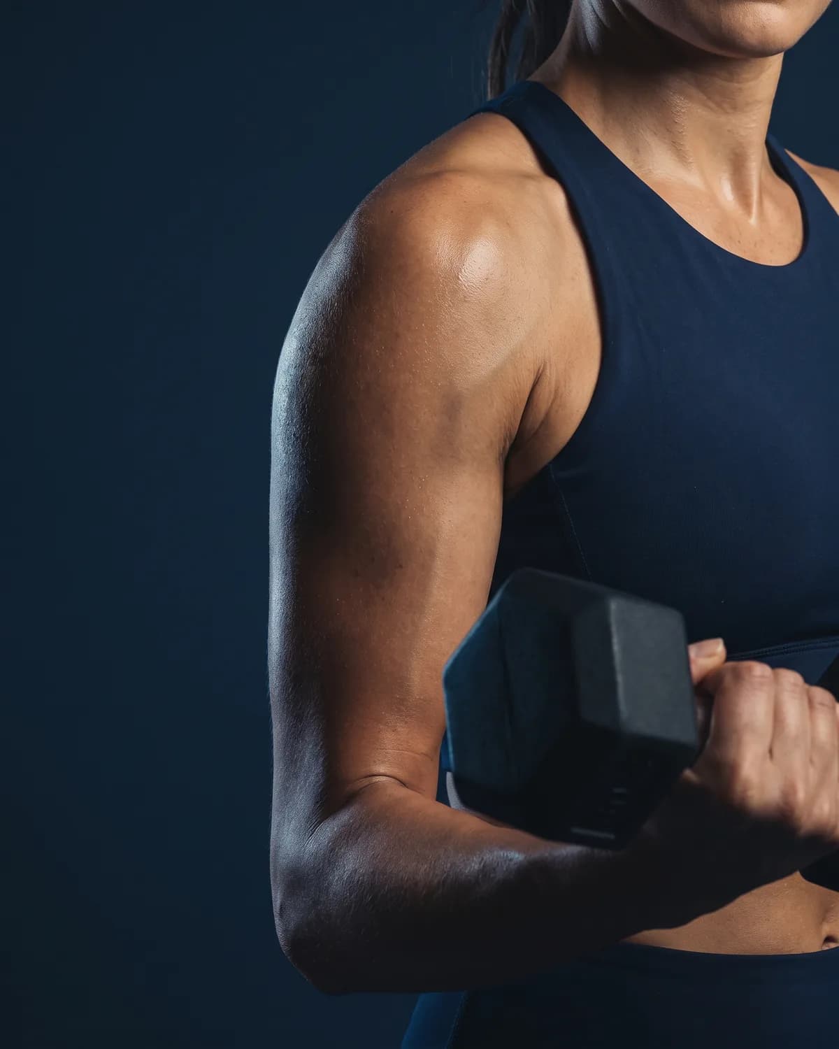 A toned shoulder and arm lifting a dumbbell